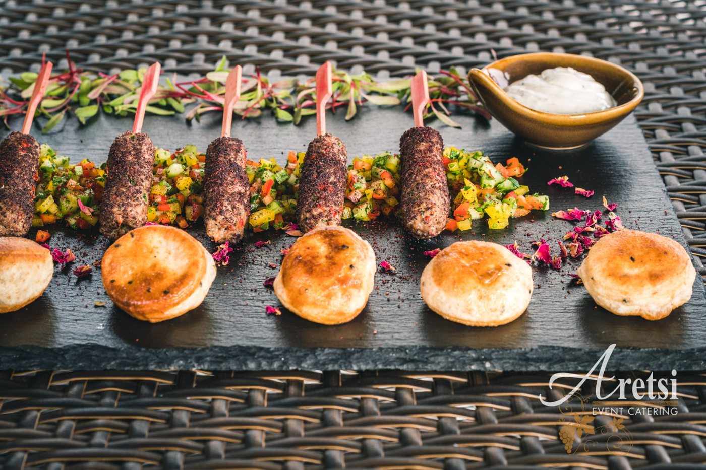 Sumac lamb kofta skewers with chopped salad, flatbreads and tzatziki on slate