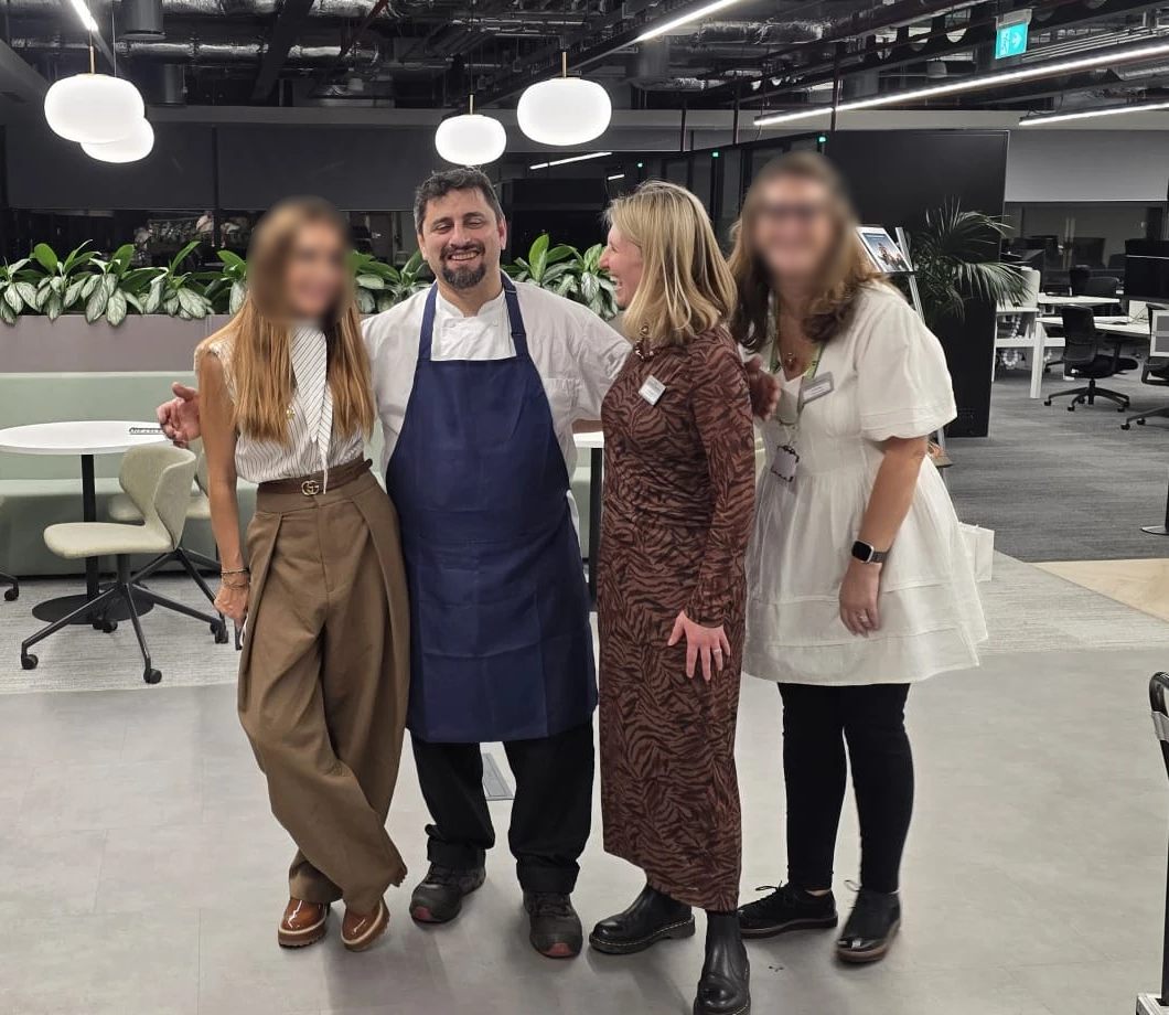 Chef Ioannis with smiling guests at an Aretsi corporate event