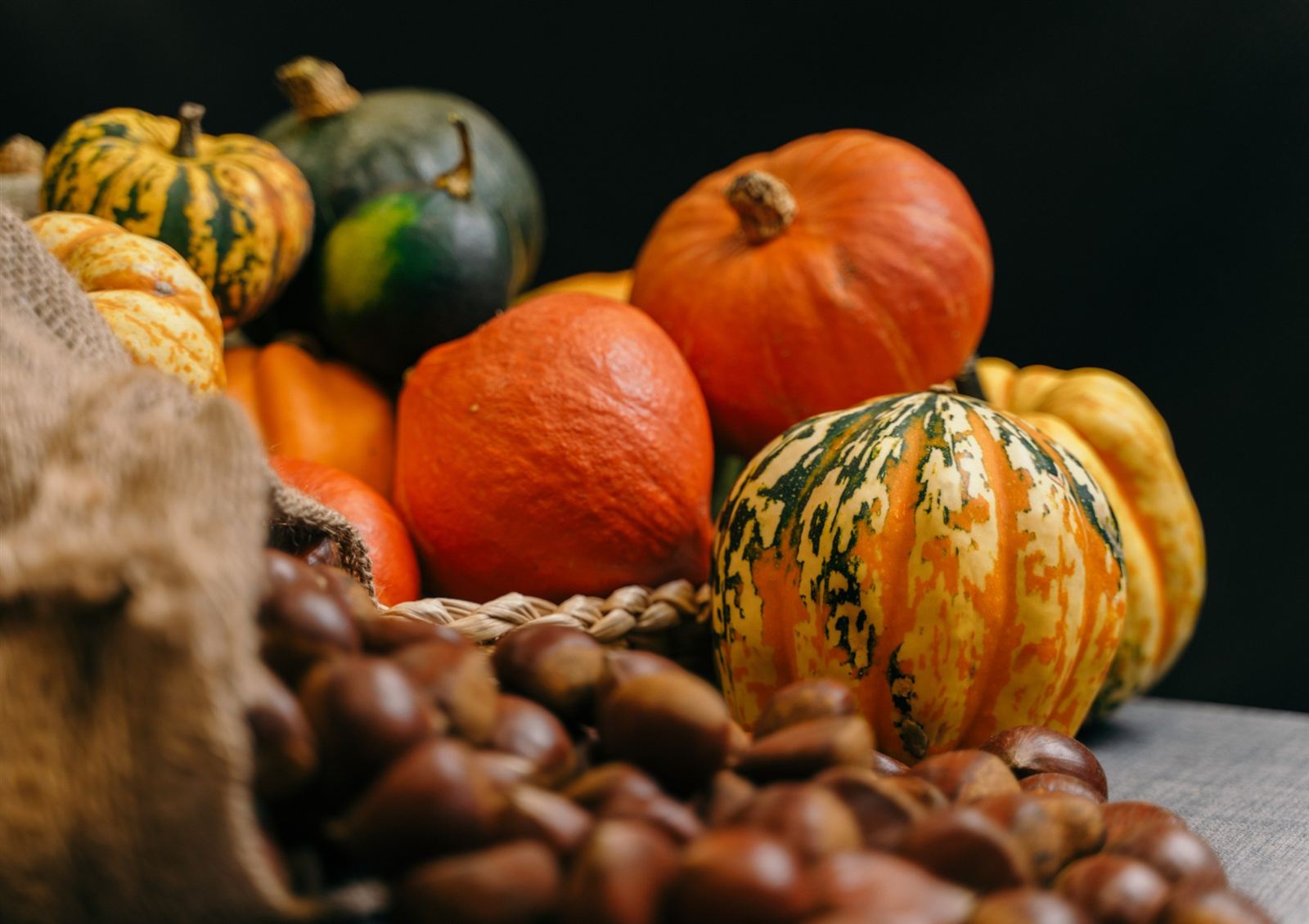 Winter squash and fresh chestnuts from the market, piled on a basket and hessian sack