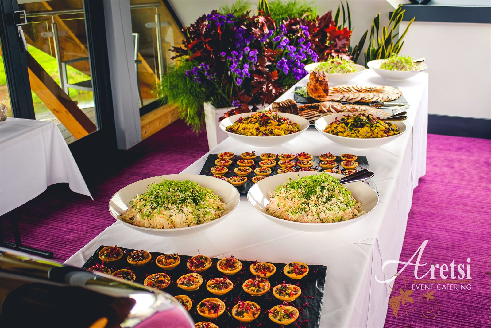 A hot and cold buffet with salads and roast meats