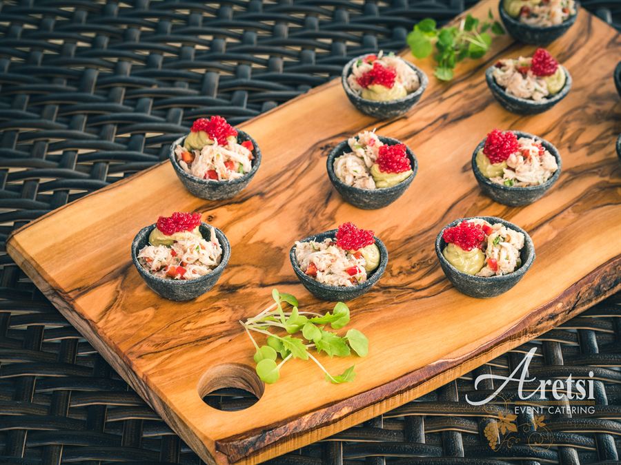 Canapés presented on an olive wood board