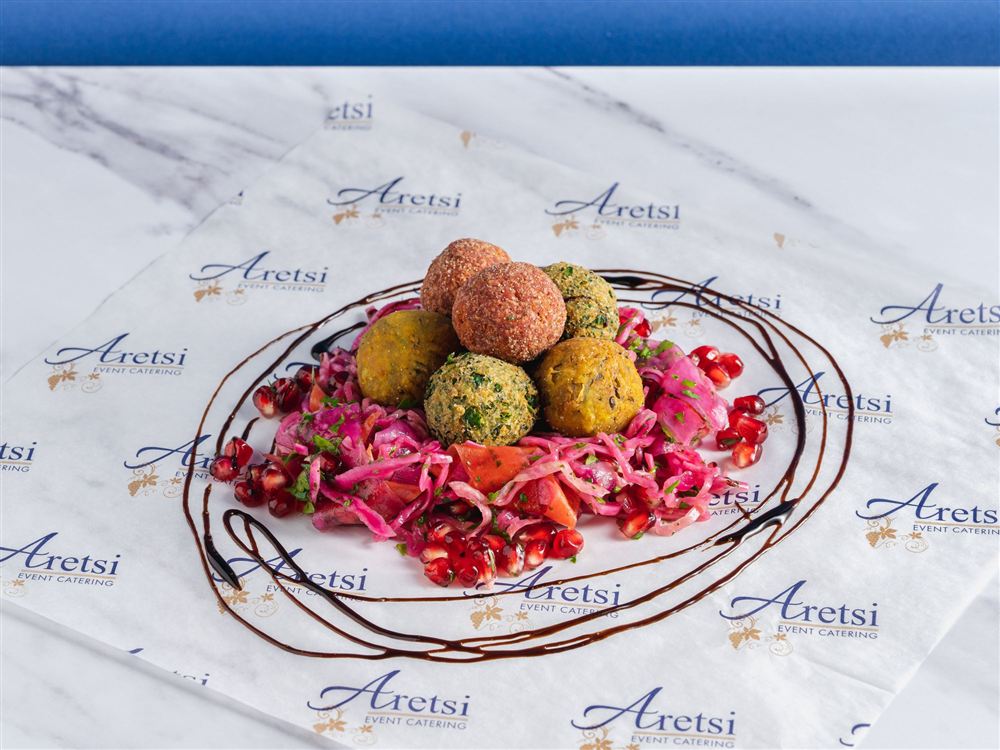 A trio of Aretsi falafel on red cabbage slaw with pomegranate and balsamic