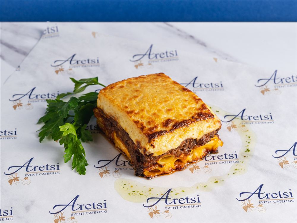 A slice of Aretsi pastitsio showing layers of pasta, mince and béchamel