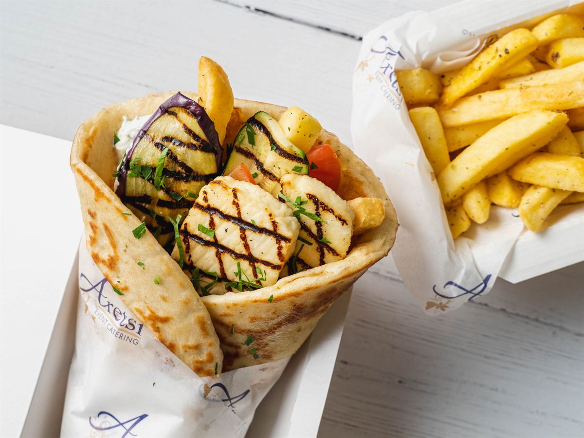 An Aretsi grilled halloumi pitta beside a box of oregano fries