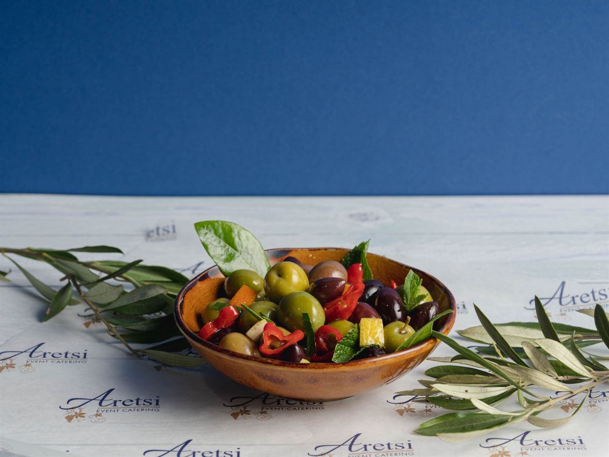 Marinated Greek olives in a bowl on Aretsi paper