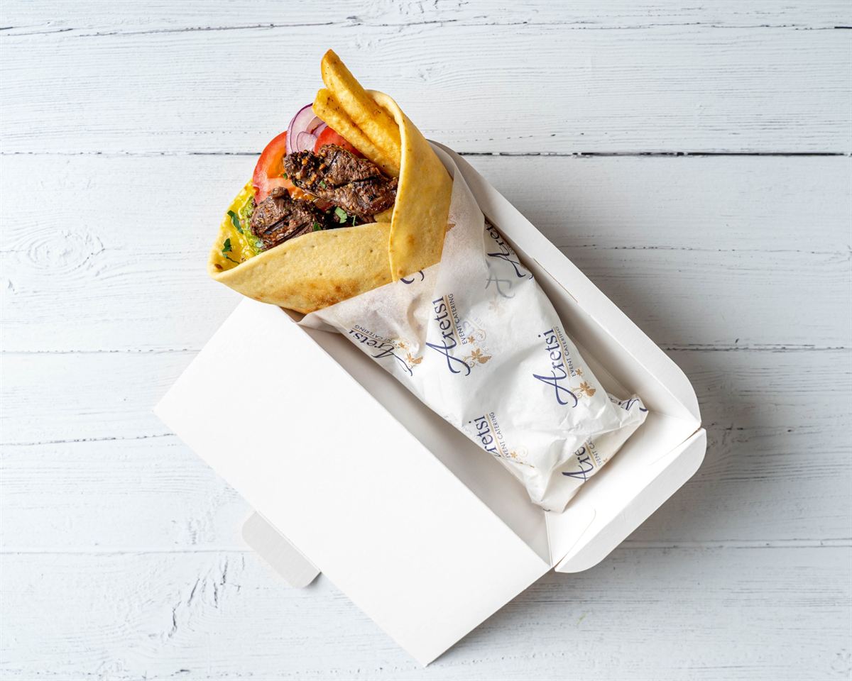 An Aretsi steak pitta with tomato, red onion and fries
